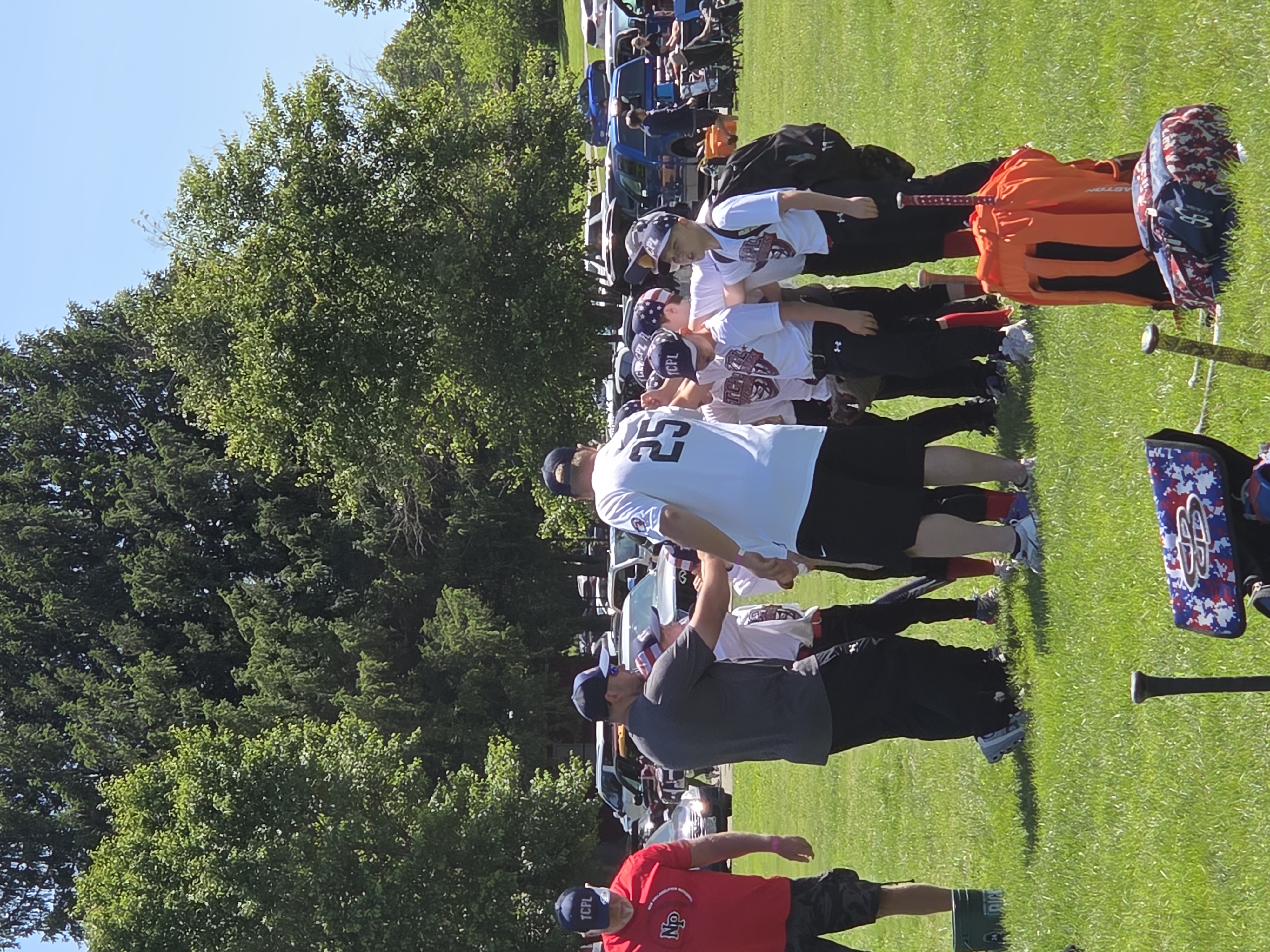 Baseball players around their coach, preparing for a game.
